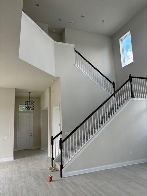 stairs featuring a high ceiling and wood-type flooring