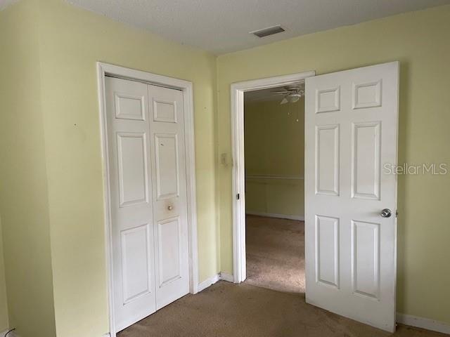 unfurnished bedroom featuring a closet and dark colored carpet