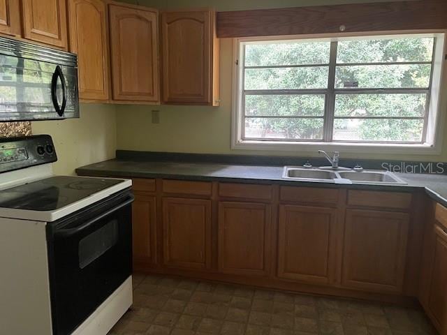 kitchen with white range with electric cooktop, sink, and light tile floors