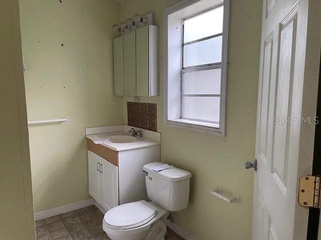 bathroom featuring toilet, vanity, and tile flooring