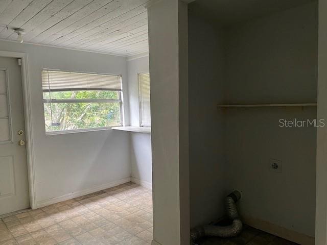 laundry room featuring electric dryer hookup and light tile flooring