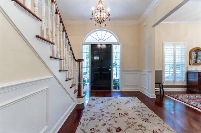 entryway with dark hardwood / wood-style floors, a notable chandelier, and crown molding