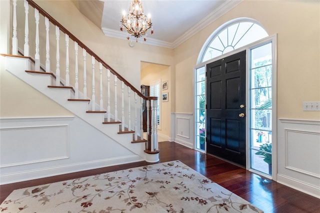 foyer featuring ornamental molding, dark hardwood / wood-style floors, and an inviting chandelier