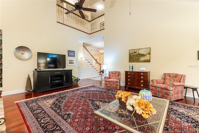 living room featuring a towering ceiling, ceiling fan, and dark hardwood / wood-style floors