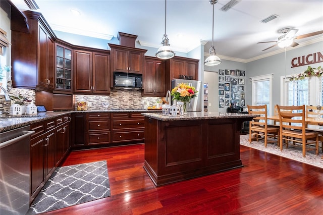 kitchen with hanging light fixtures, dark hardwood / wood-style flooring, appliances with stainless steel finishes, tasteful backsplash, and ceiling fan