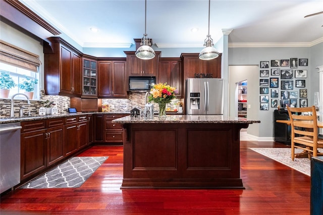 kitchen featuring a kitchen island, dark wood-type flooring, tasteful backsplash, and appliances with stainless steel finishes