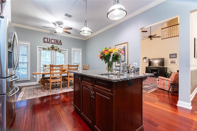 kitchen with a kitchen island with sink, stainless steel fridge with ice dispenser, ceiling fan, and dark hardwood / wood-style flooring