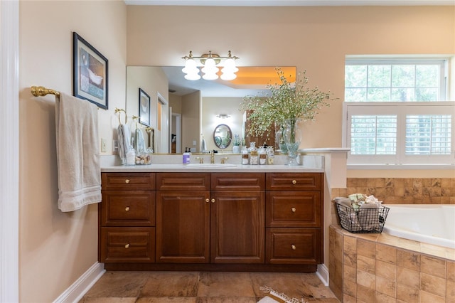 bathroom featuring tile floors, tiled tub, and vanity