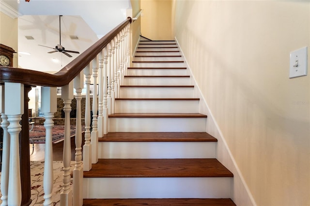 stairway featuring ceiling fan