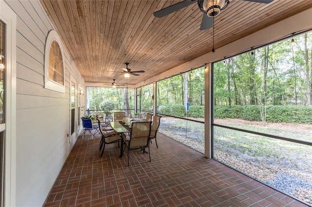 unfurnished sunroom featuring wood ceiling and ceiling fan