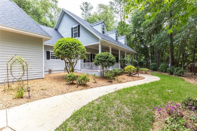 exterior space with covered porch and a yard