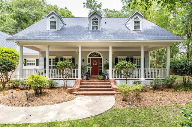 cape cod home featuring covered porch