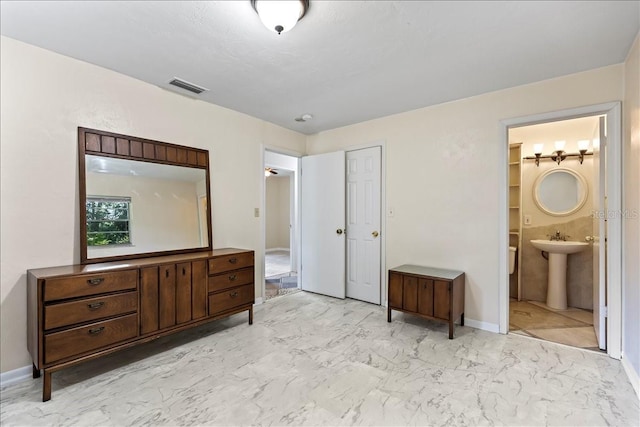 tiled bedroom with connected bathroom, a closet, and sink