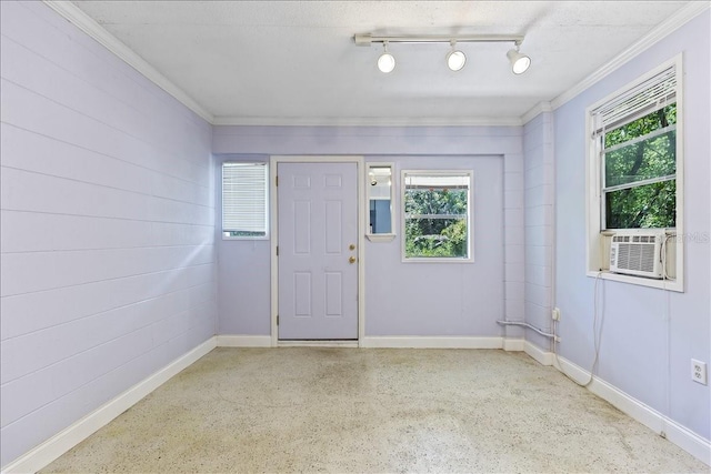 empty room with track lighting, a textured ceiling, and a wealth of natural light