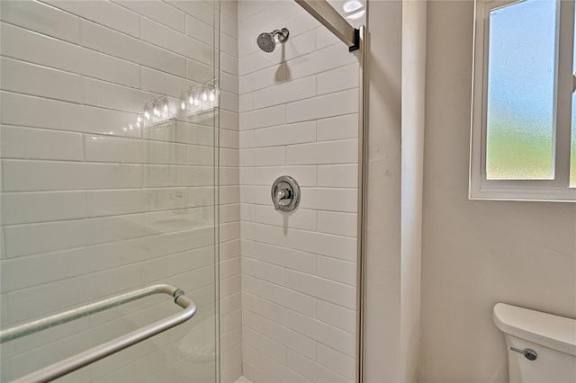 bathroom featuring a tile shower and toilet