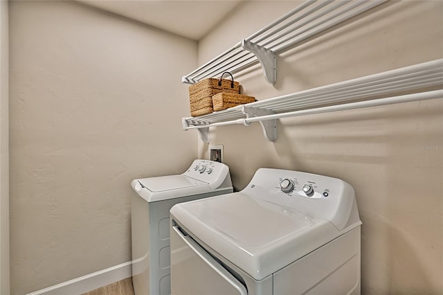 laundry area with washer hookup, washing machine and dryer, and hardwood / wood-style flooring