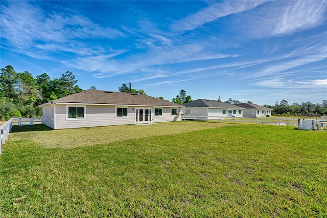 rear view of property featuring a lawn