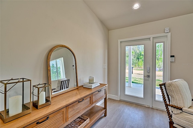 entryway with lofted ceiling and light hardwood / wood-style flooring