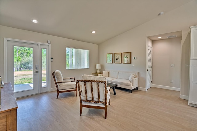 living room with light hardwood / wood-style floors and vaulted ceiling