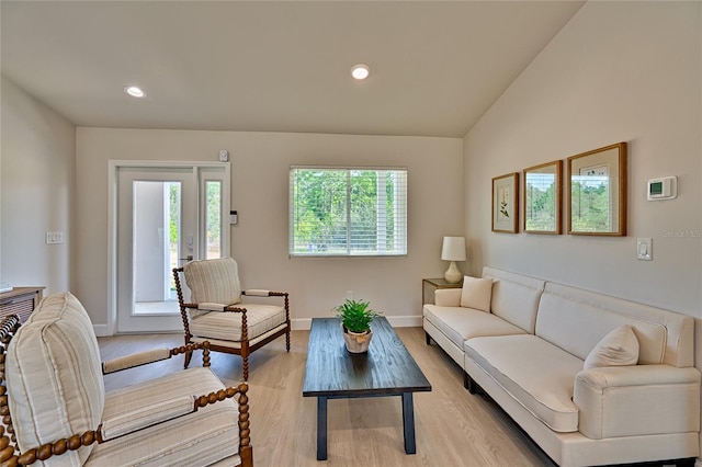 living room with vaulted ceiling, light hardwood / wood-style floors, and a healthy amount of sunlight