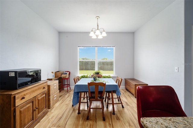 dining area featuring light hardwood / wood-style flooring and a chandelier