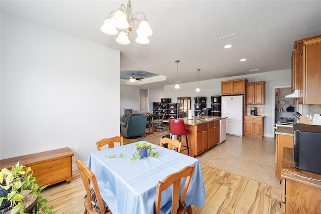 dining room featuring ceiling fan with notable chandelier, sink, and light tile flooring