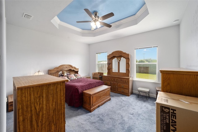 bedroom with ceiling fan, ornamental molding, light carpet, and a raised ceiling