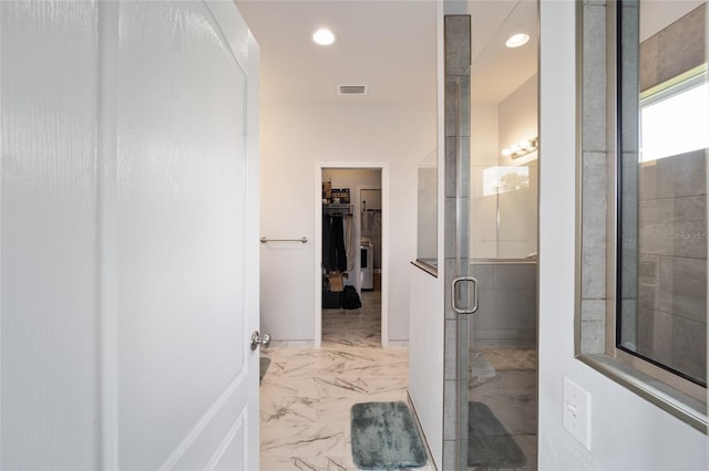 bathroom with tile flooring and a shower with door