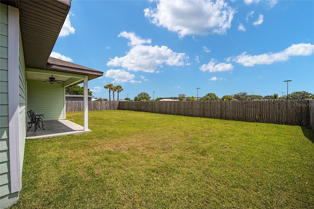 view of yard with ceiling fan and a patio area