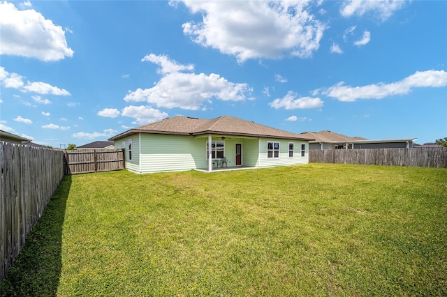 rear view of house featuring a yard and a patio area