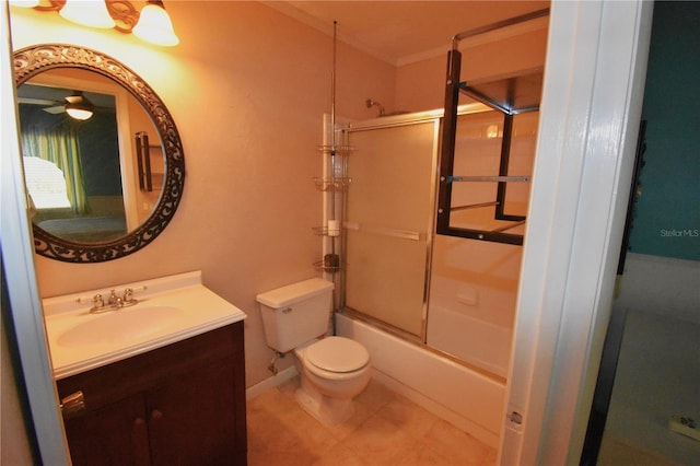 full bathroom with vanity with extensive cabinet space, bath / shower combo with glass door, tile flooring, toilet, and ceiling fan