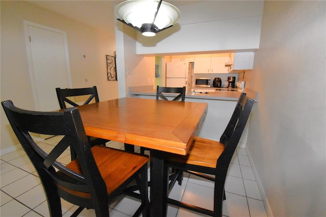 dining area with sink and light tile flooring