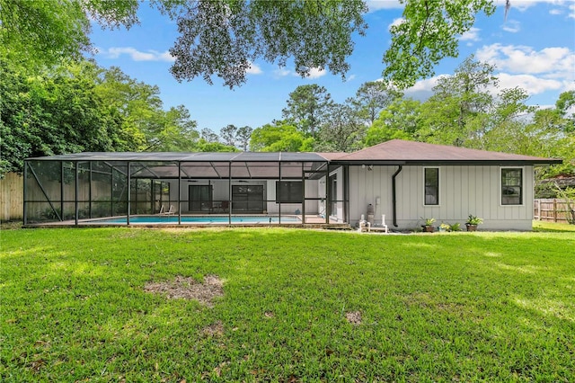 back of house with glass enclosure, a fenced in pool, and a lawn