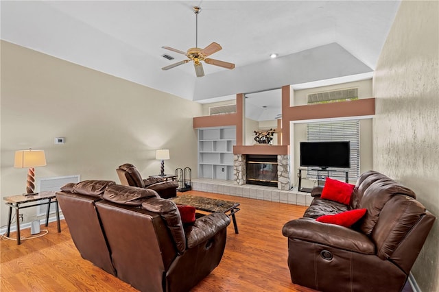 living room with ceiling fan, lofted ceiling, light hardwood / wood-style flooring, and built in shelves