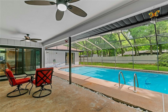 view of swimming pool with ceiling fan, a lanai, and a patio