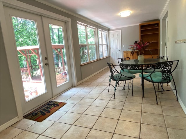 dining space featuring light tile patterned floors, crown molding, and french doors