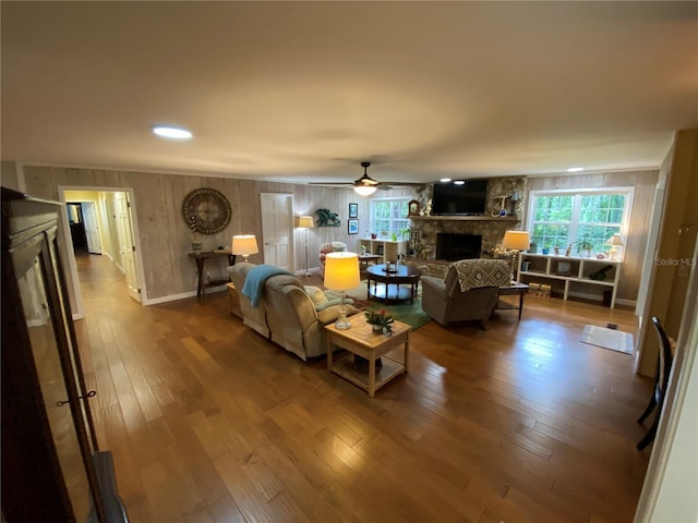 living room featuring ceiling fan, hardwood / wood-style floors, and a fireplace