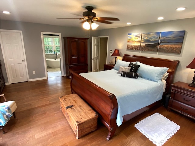 bedroom with ceiling fan, connected bathroom, and hardwood / wood-style flooring