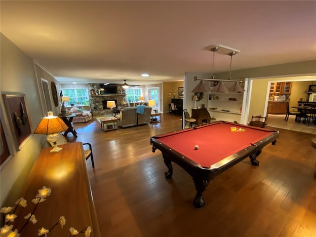 game room featuring ceiling fan, hardwood / wood-style flooring, a stone fireplace, and billiards