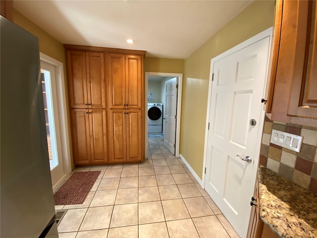 hallway with light tile patterned floors and washer / clothes dryer