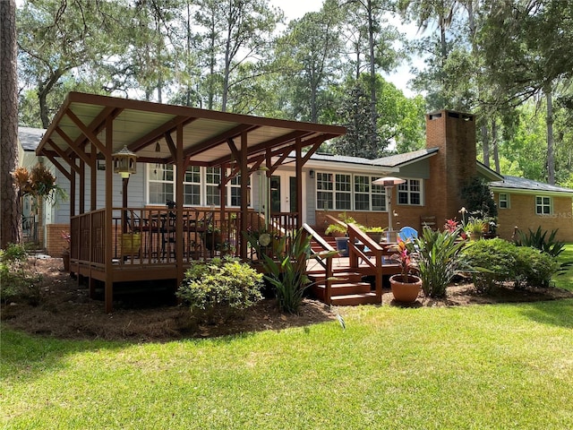 rear view of property with a lawn and a wooden deck