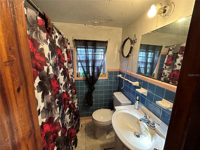 bathroom featuring tile walls, sink, tasteful backsplash, toilet, and tile floors