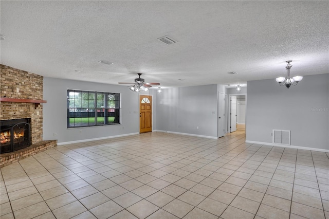 unfurnished living room with light tile patterned flooring, a fireplace, visible vents, and ceiling fan with notable chandelier