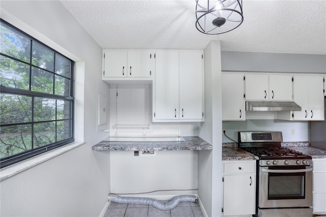 kitchen with stainless steel gas range oven, white cabinetry, and under cabinet range hood