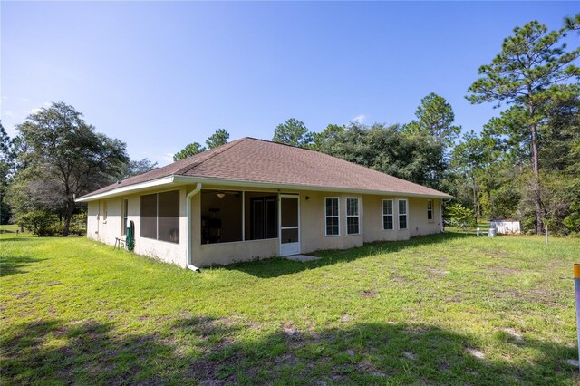 back of property featuring a sunroom and a yard