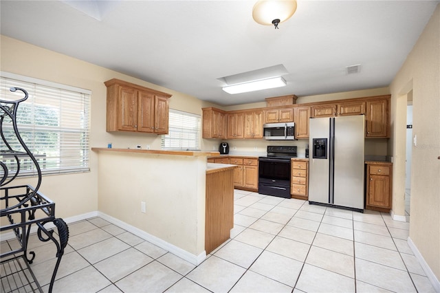 kitchen featuring appliances with stainless steel finishes, kitchen peninsula, and light tile patterned floors