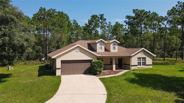 view of front of house featuring a front yard, cooling unit, and a garage