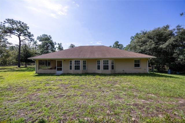 rear view of house featuring a lawn