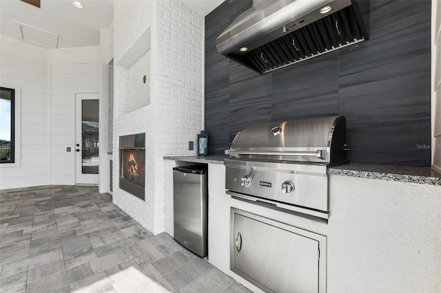 kitchen with refrigerator, tile flooring, and a fireplace