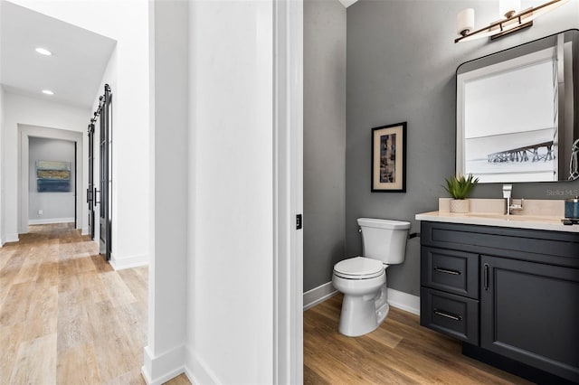 bathroom with hardwood / wood-style flooring, vanity, and toilet